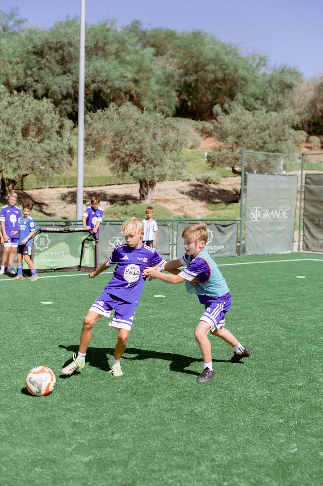 Two players shoulder to shoulder challenging for the ball