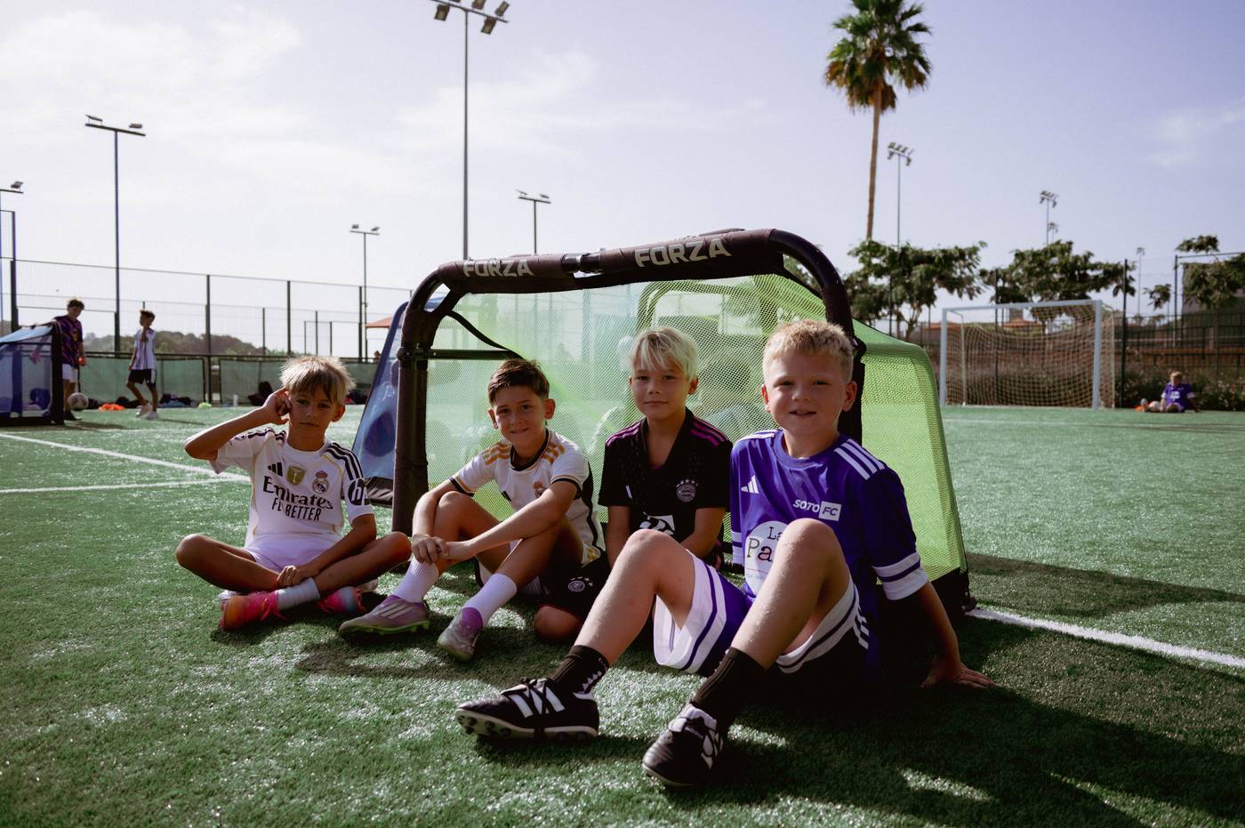 Four young players sitting by the goal at La Reserva